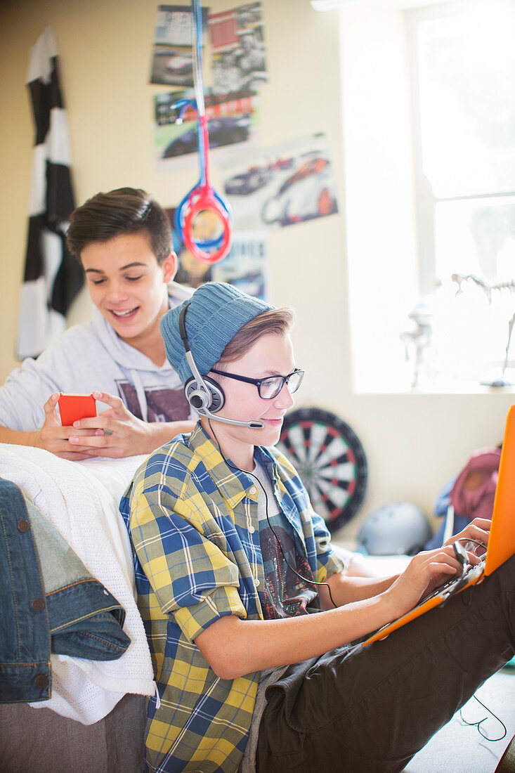 Boys using electronic devices in room