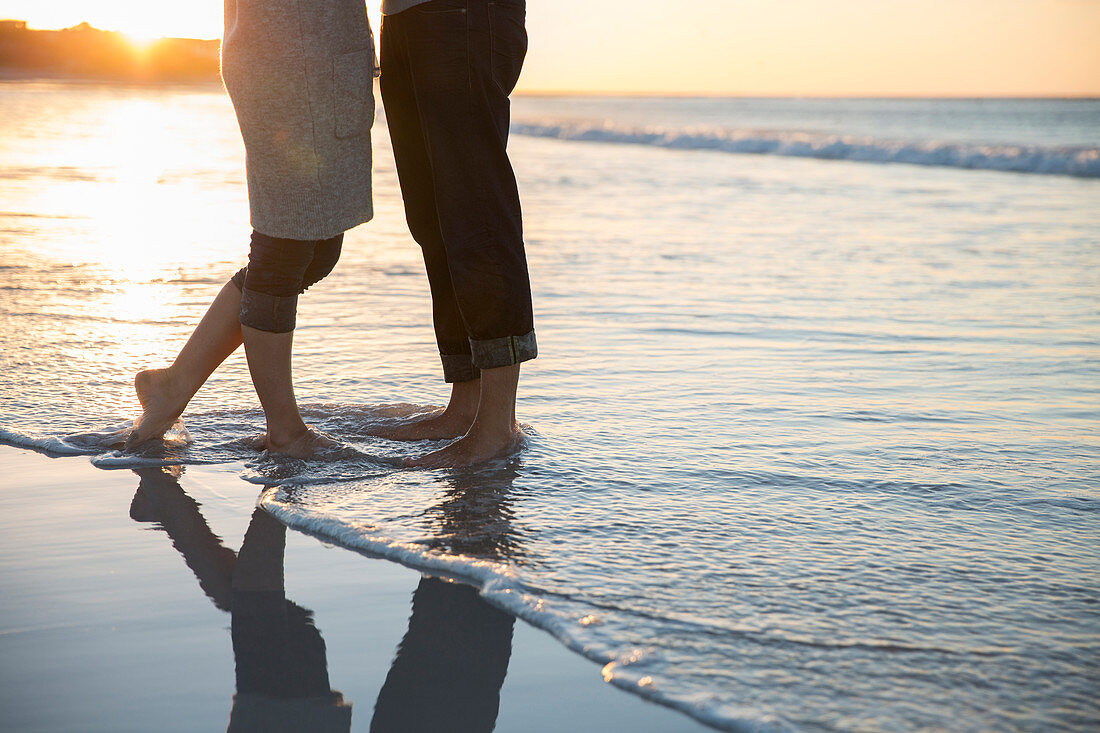 Legs of young couple standing on beach