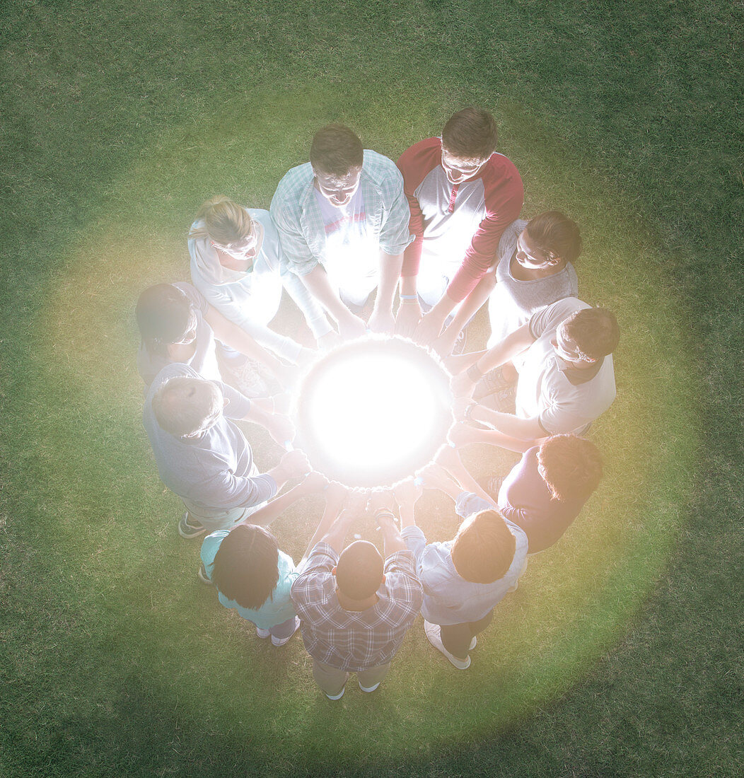 Team in circle surrounding glowing orb