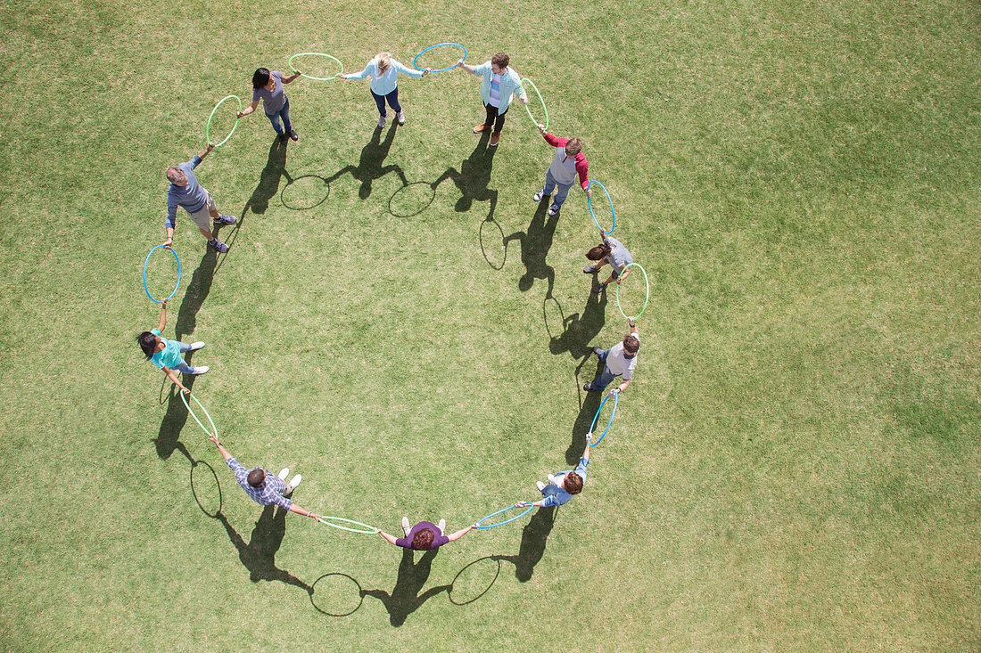 Team connected in circle in sunny field