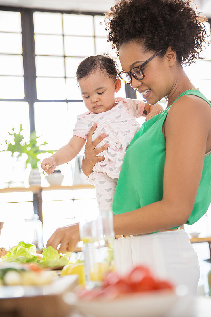 Woman with baby girl preparing meal