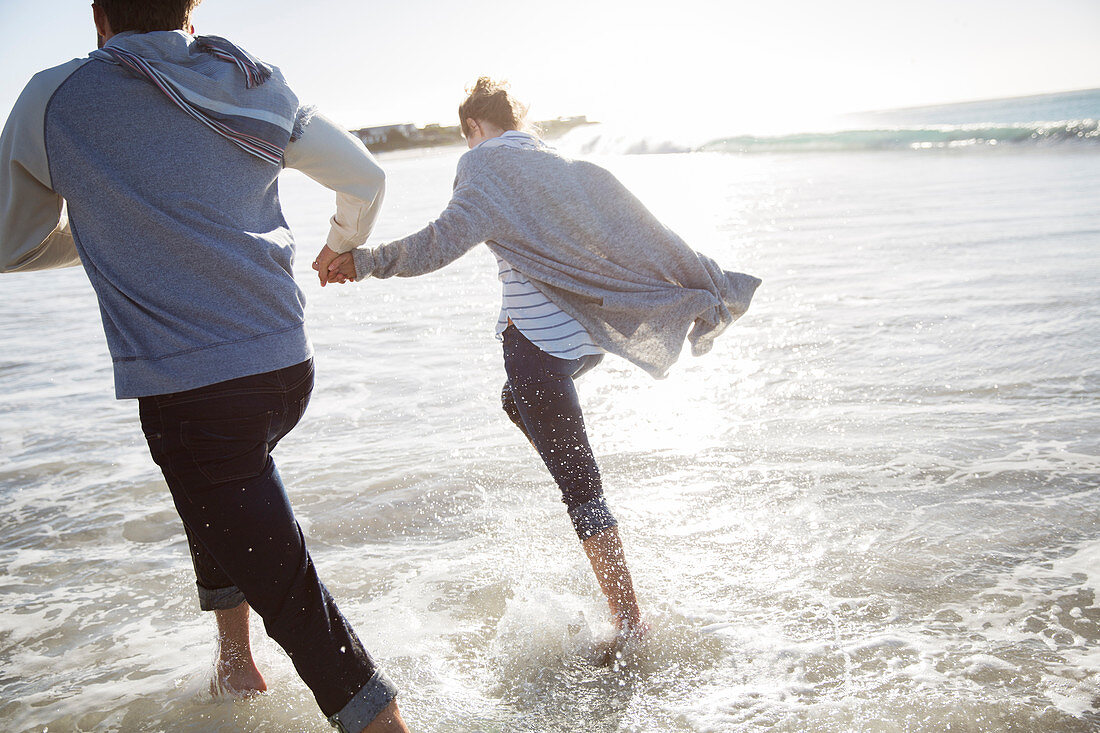 Young couple holding hands and running