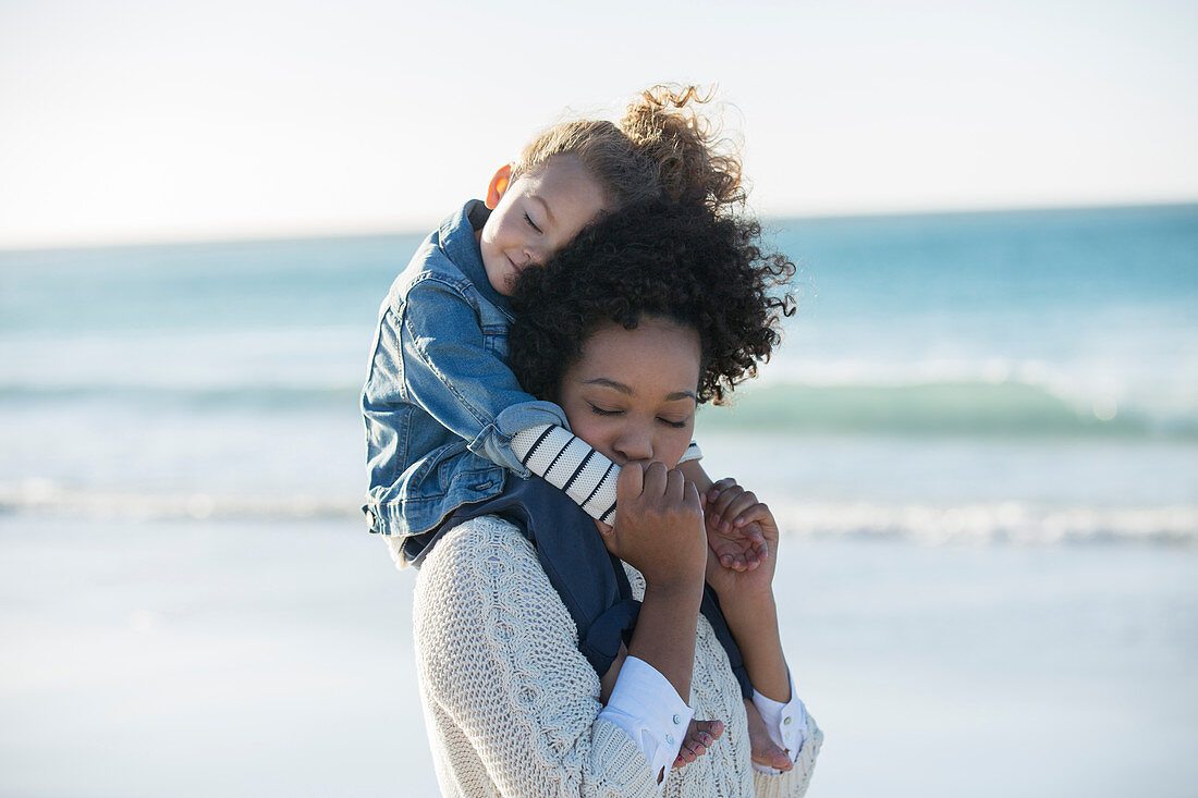 Mother carrying daughter on her shoulders