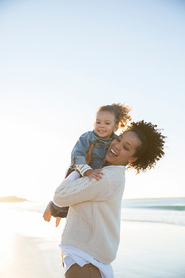 Mother and daughter embracing on beach