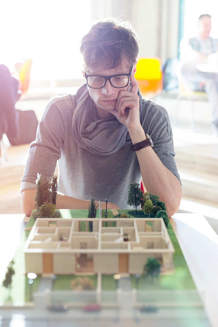 Focused architect viewing model in office