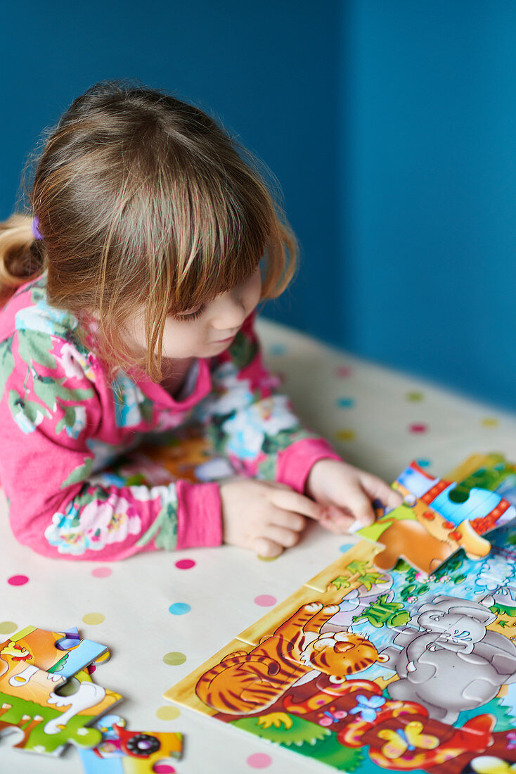 Girl assembling jigsaw puzzle