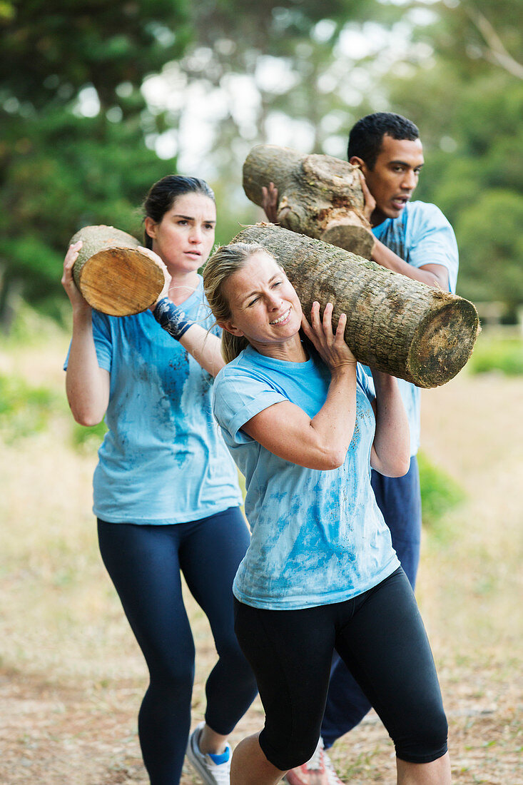 Determined woman running with log