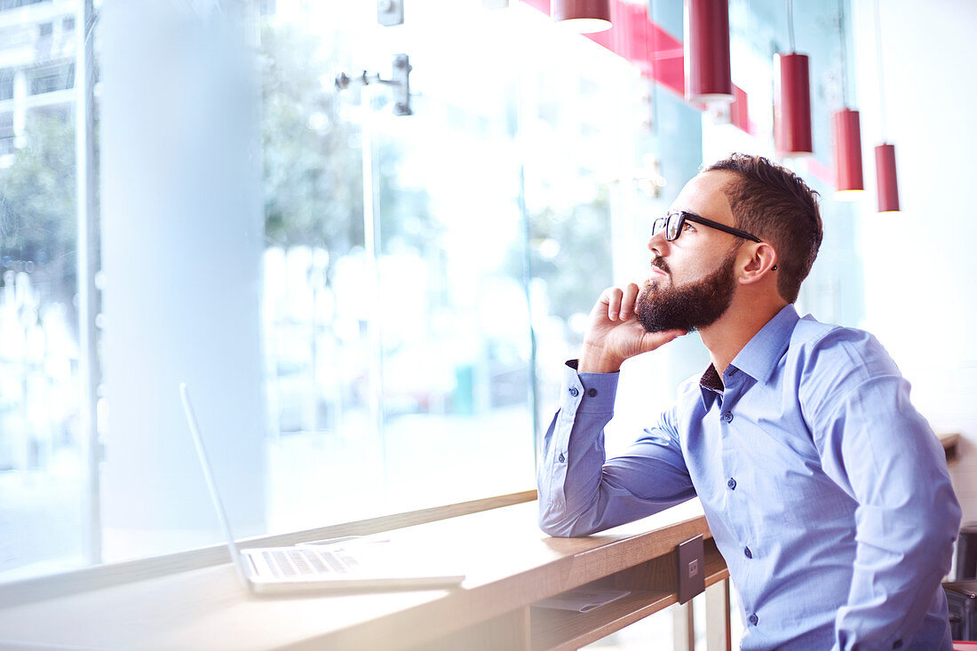 Pensive businessman at laptop in cafe