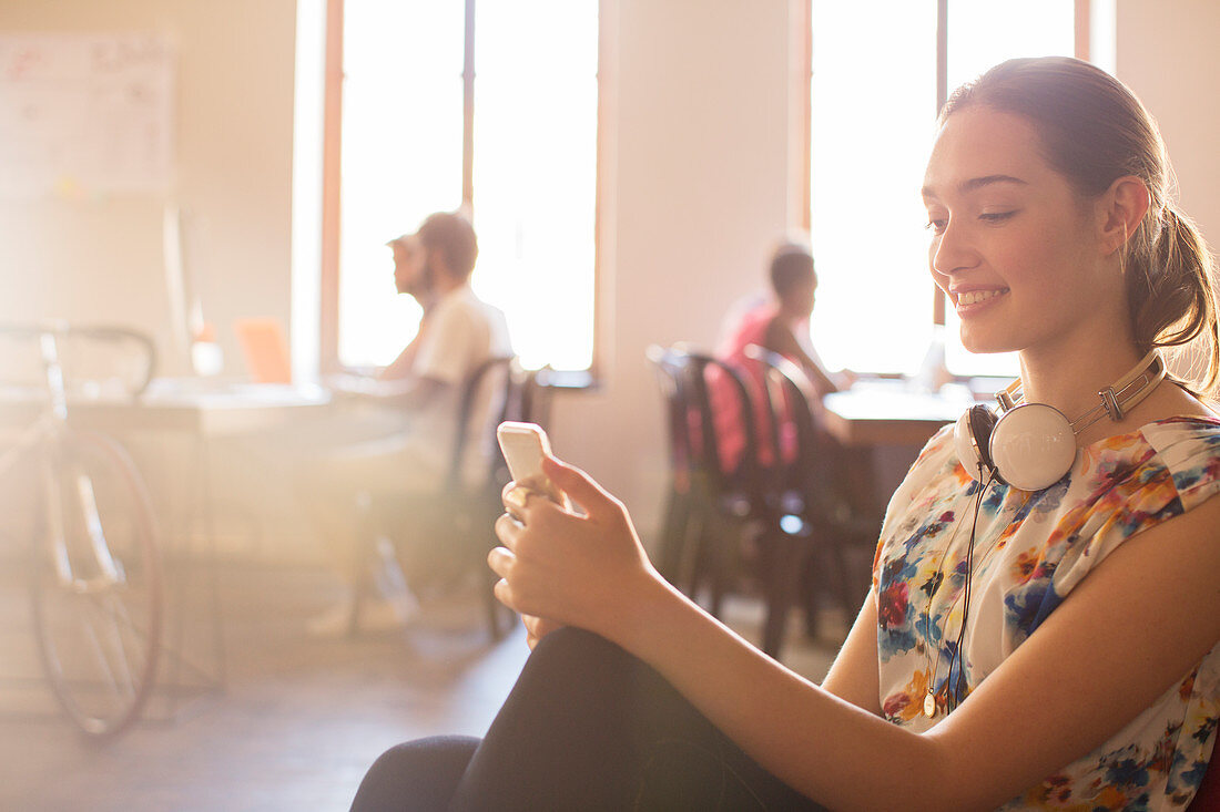 Smiling Businesswoman texting in office