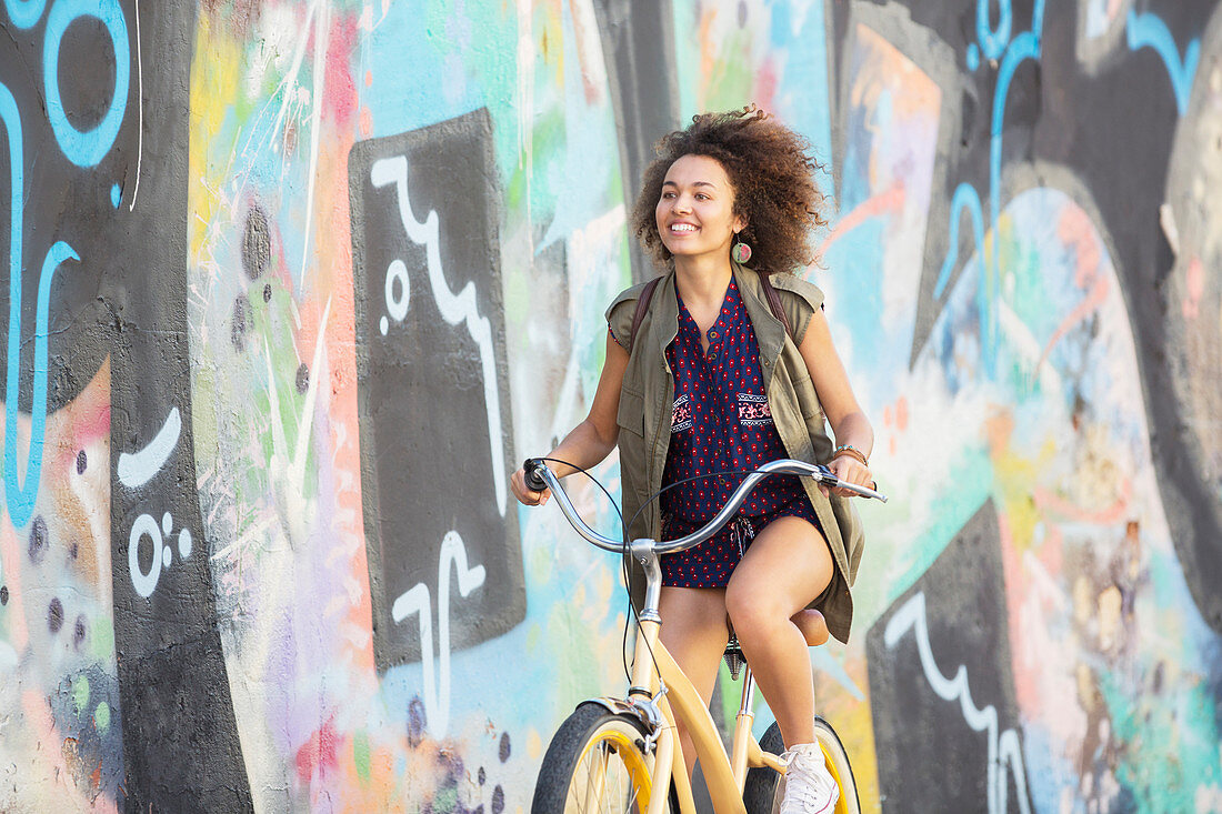 Smiling brunette woman riding bicycle