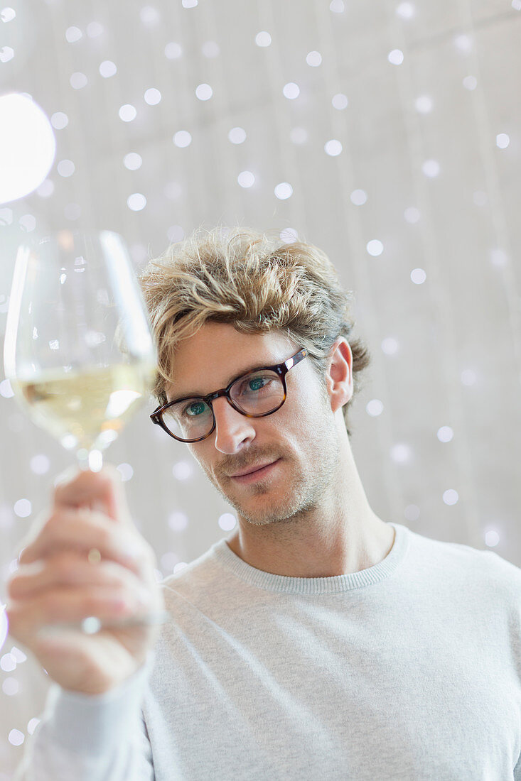 Close up man examining white wine