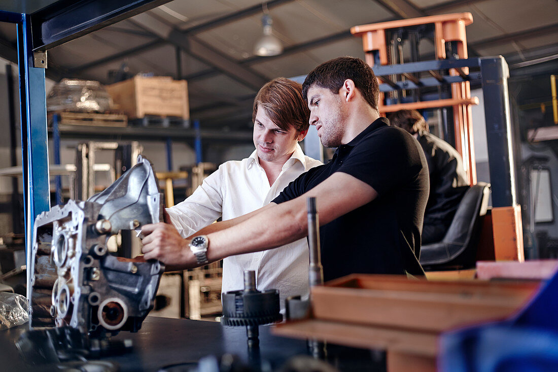 Mechanic and customer examining part