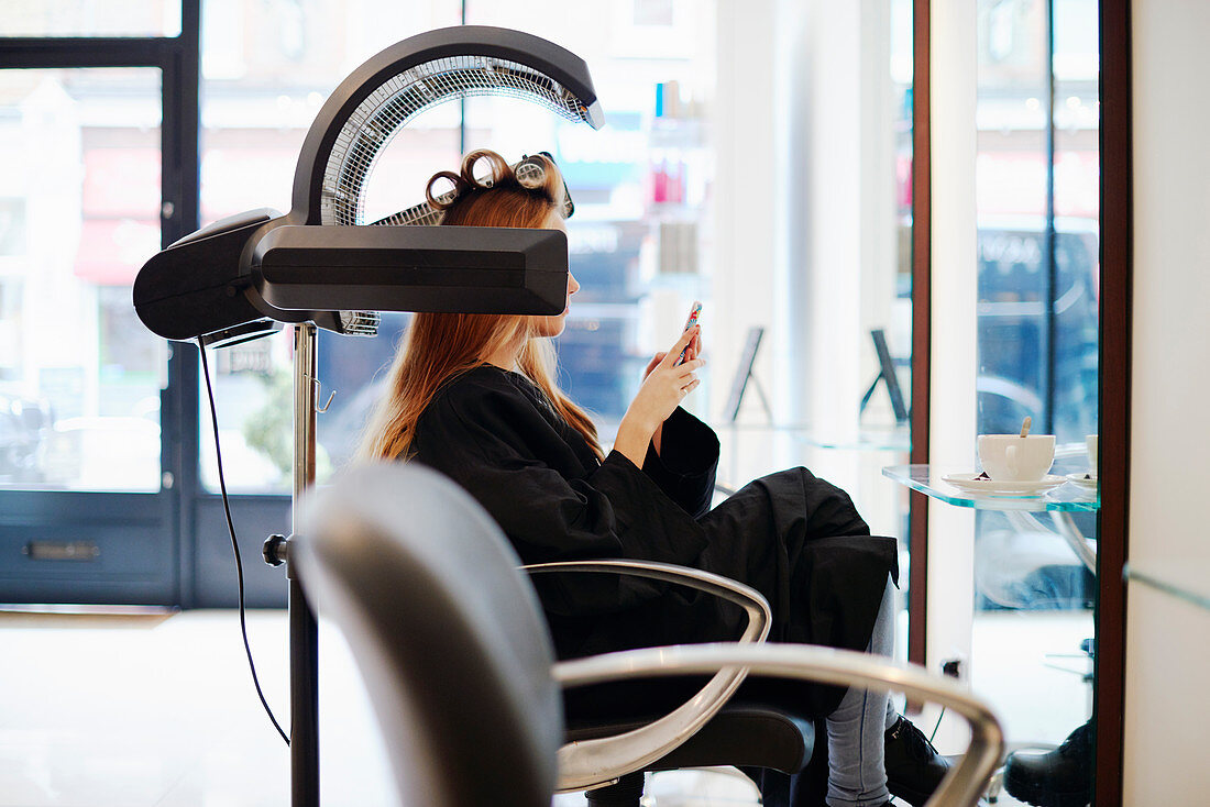 Woman texting in hair salon