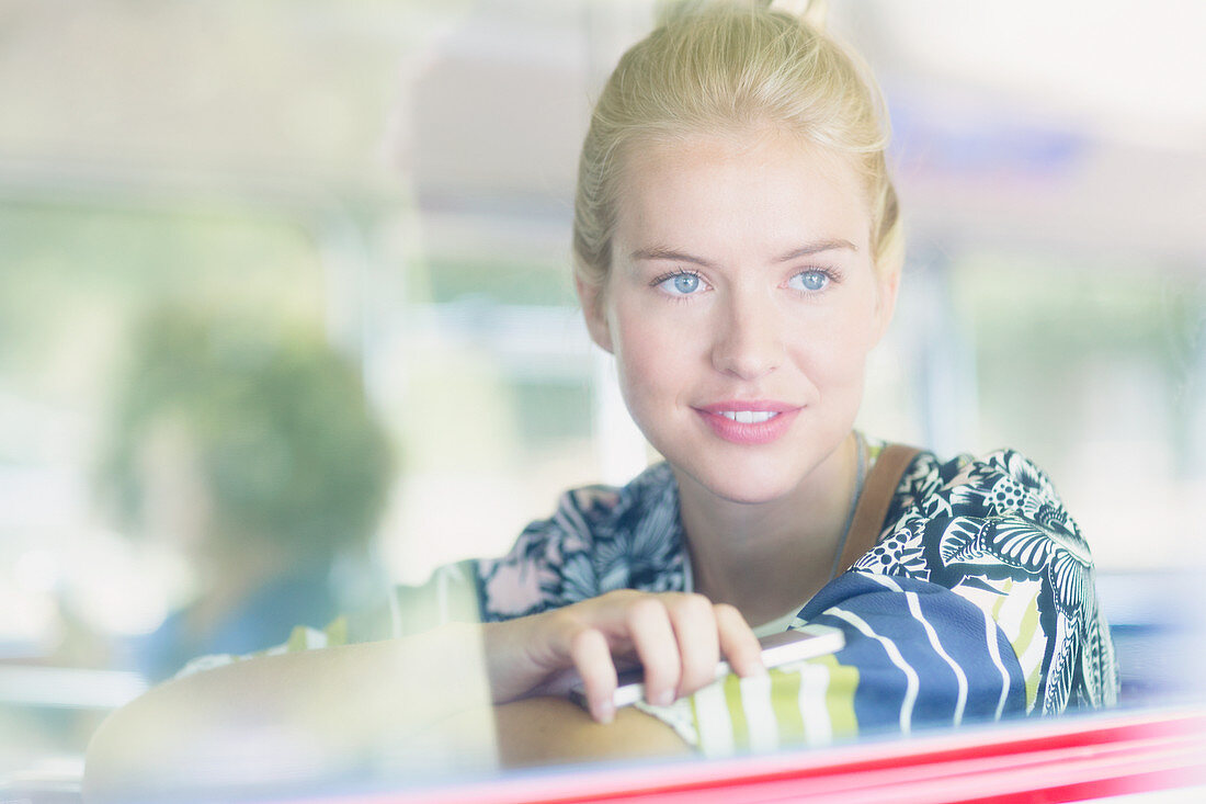 Blonde woman looking out window on bus