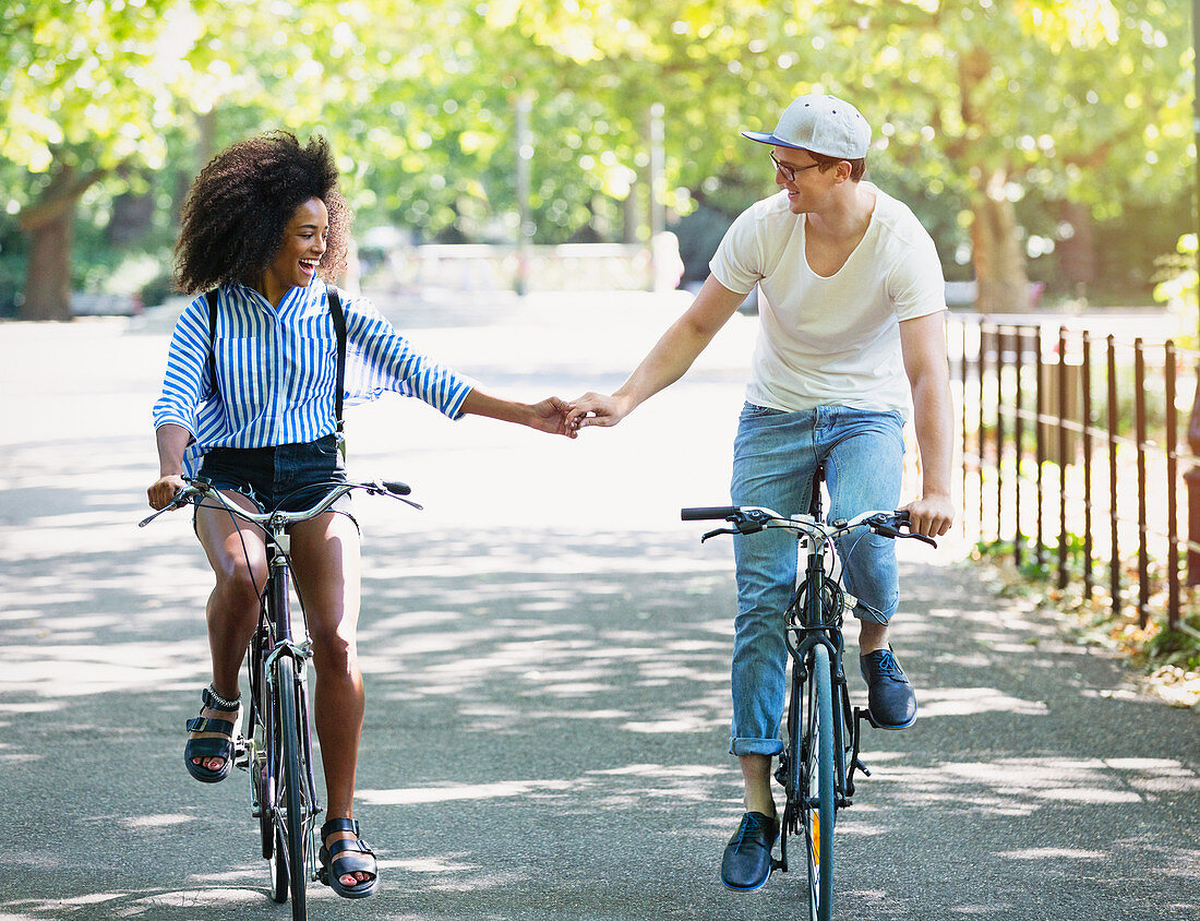 Couple holding hands riding bicycles