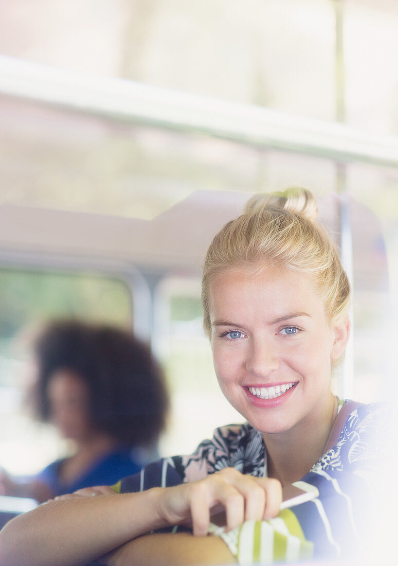 Blonde woman holding cell phone on bus