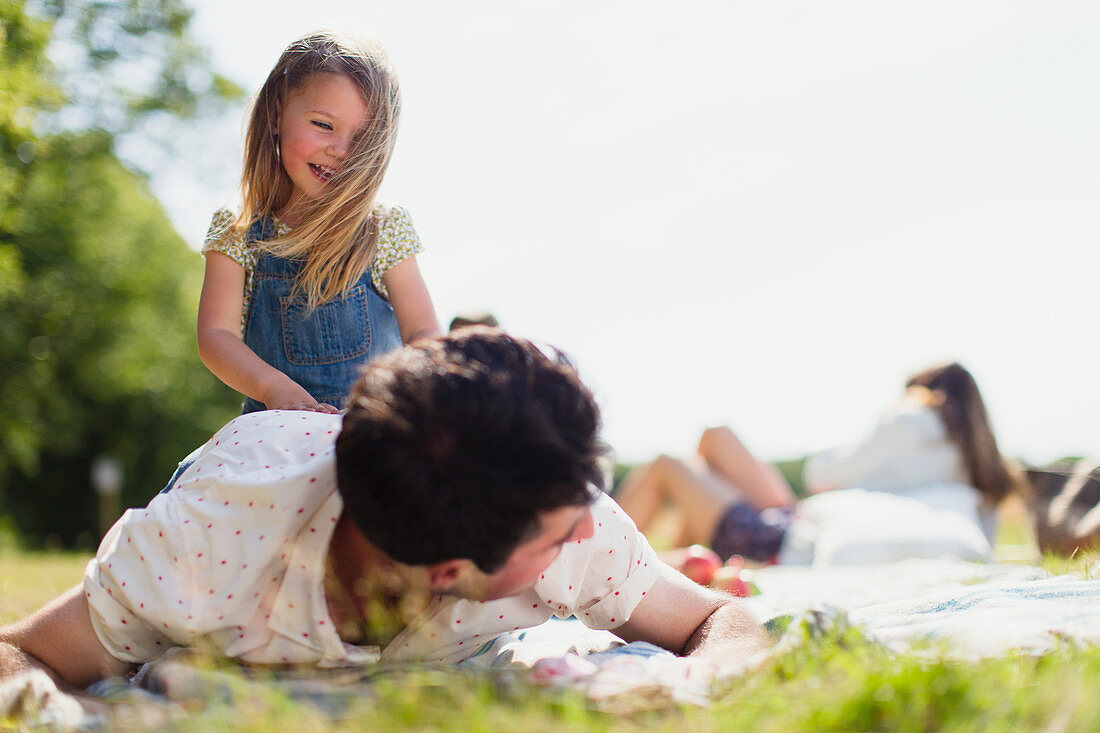 Playful daughter on top of father