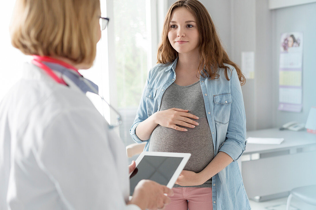 Doctor talking with pregnant teenager
