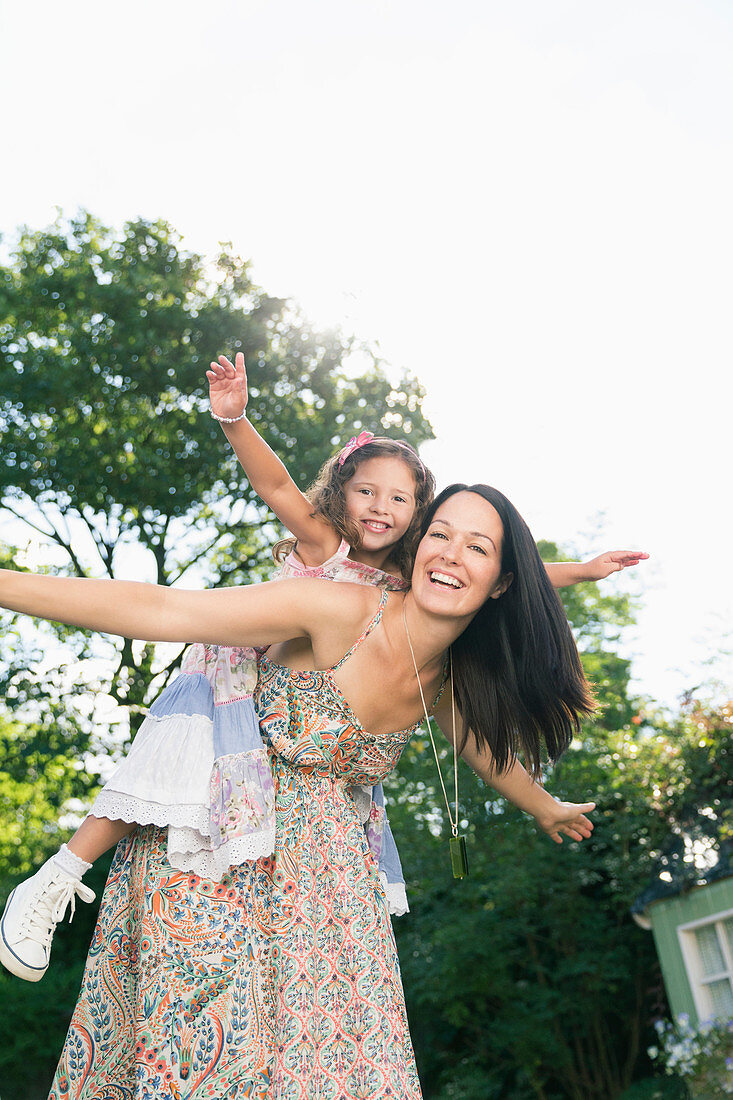 Carefree mother piggybacking daughter