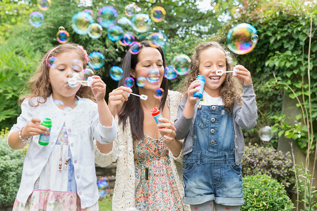 Mother and daughters blowing bubbles