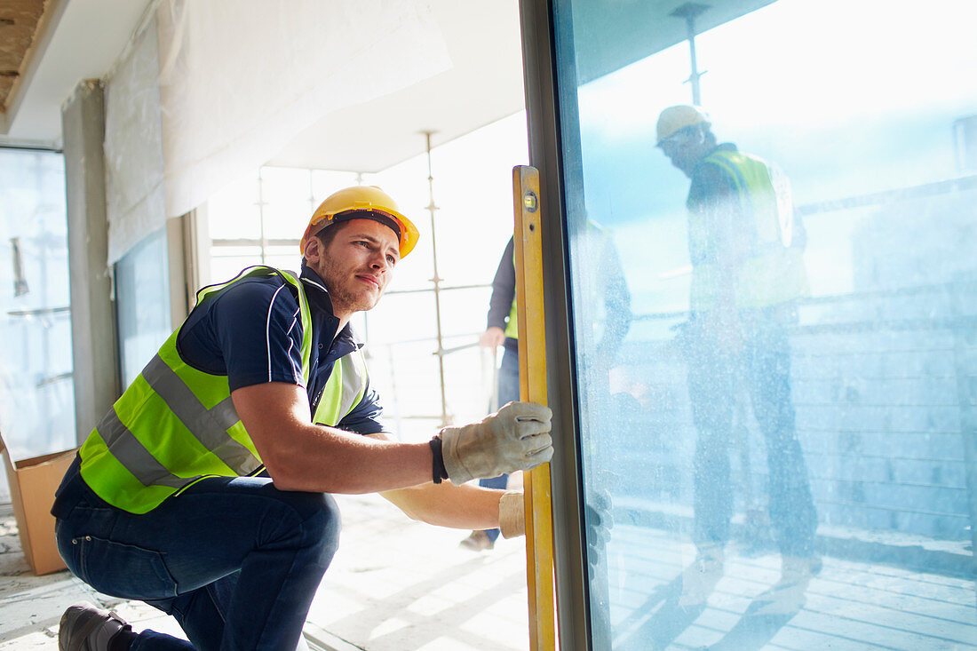 Construction worker using level tool