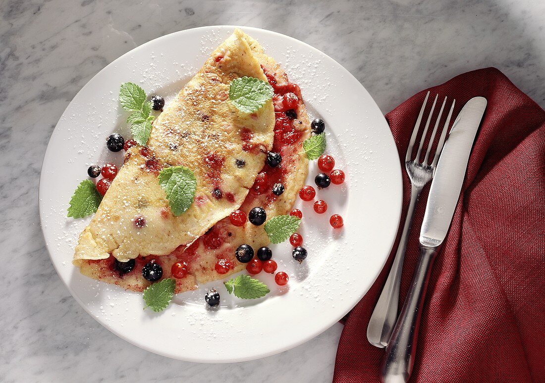 Crepe with red- and blackcurrants and mint leaves