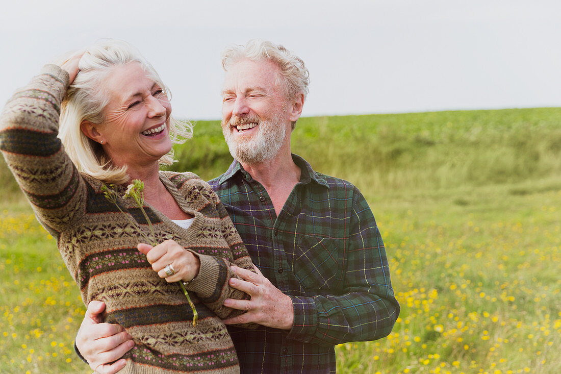 Smiling senior couple hugging in field