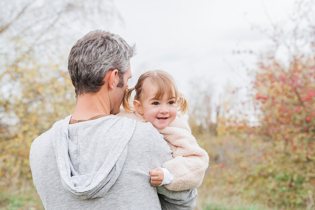 Father holding smiling toddler girl