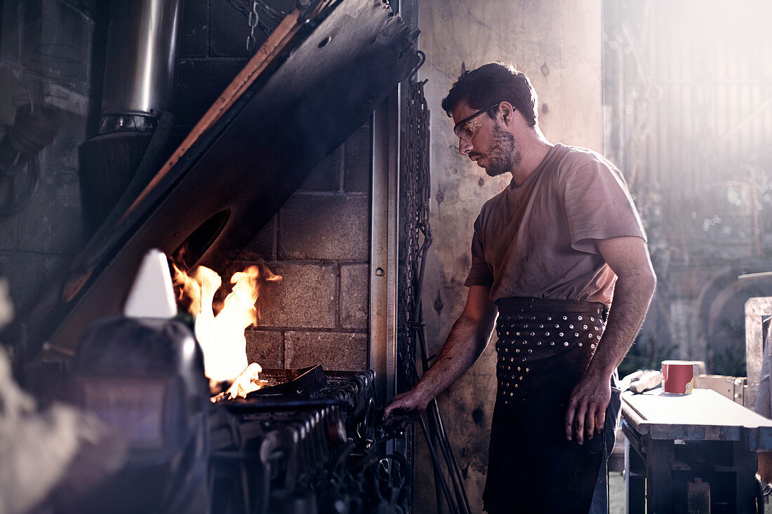Blacksmith working at fire in forge
