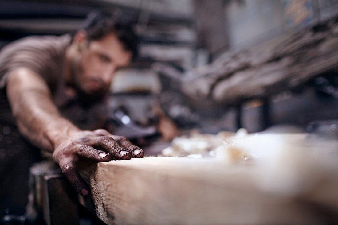Craftsman chiselling wood in workshop