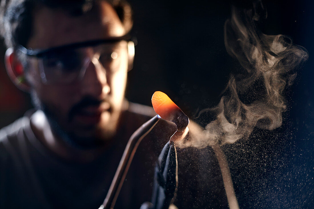 Blacksmith shaping iron with blowtorch