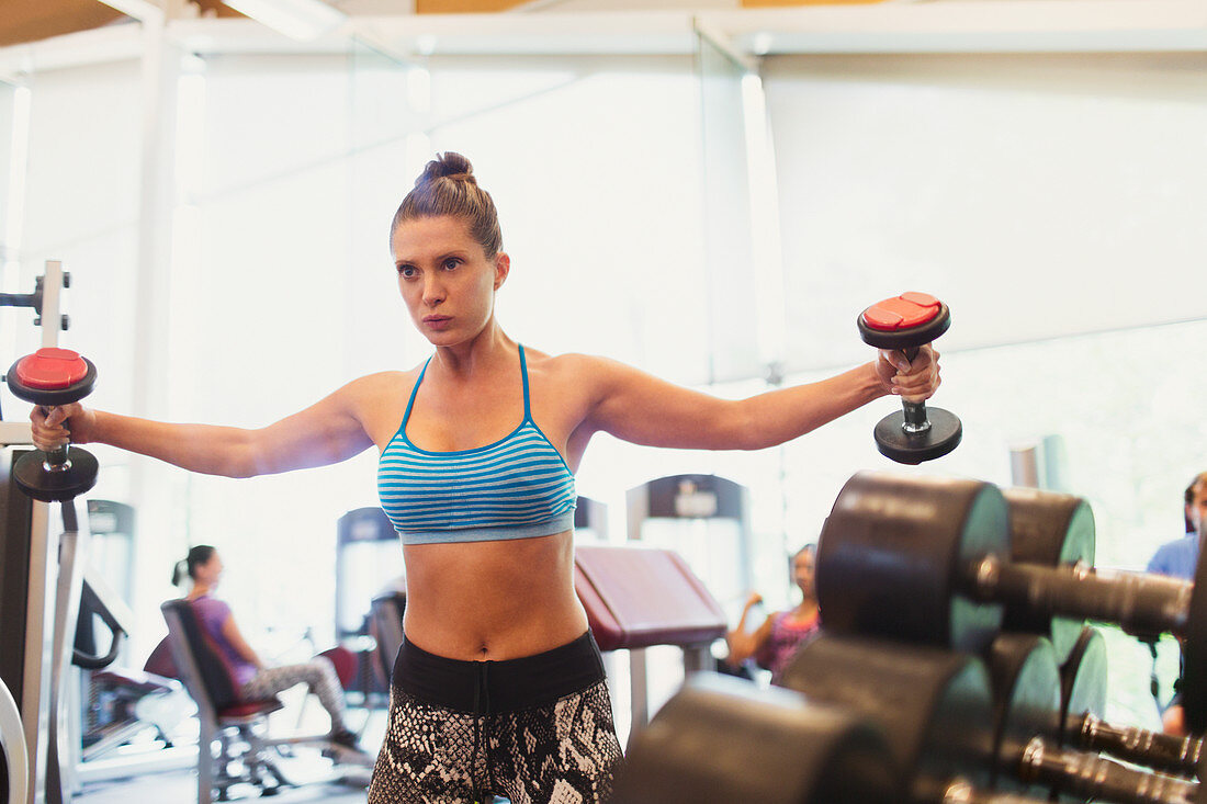 Focused woman doing dumbbell chest fly