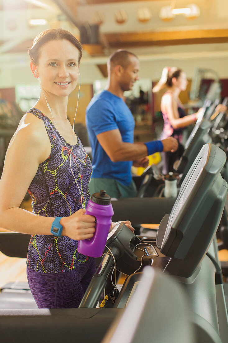 Woman with water bottle on treadmill