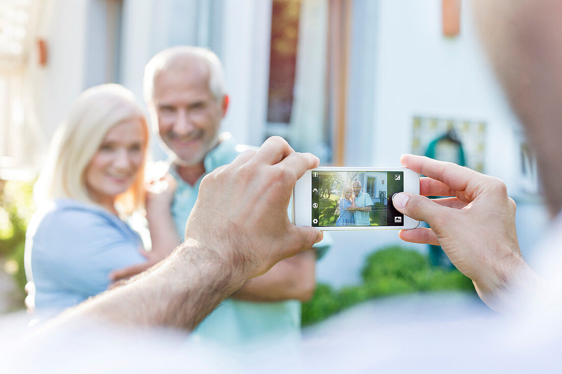 Man photographing senior couple