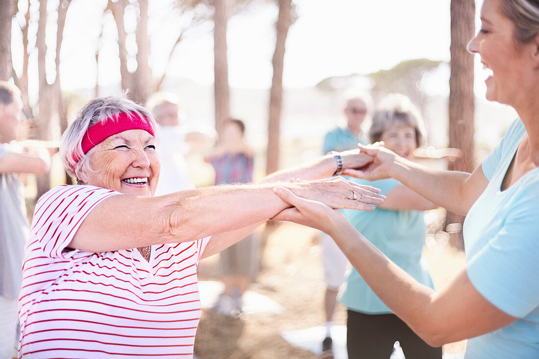 Yoga instructor guiding senior woman