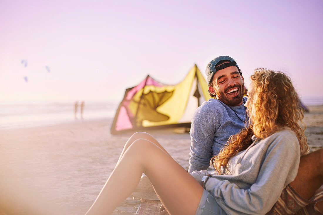 Laughing couple relaxing on sunny beach