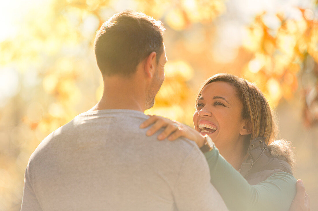 Laughing couple face to face outdoors