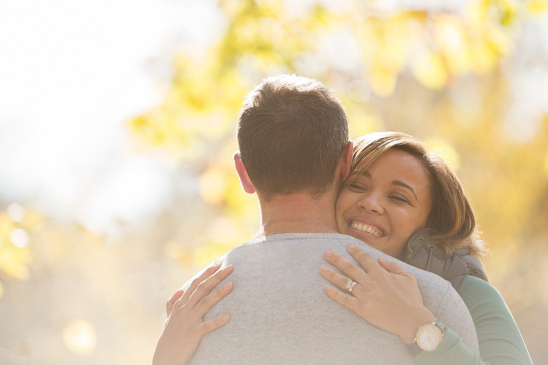 Enthusiastic couple hugging outdoors