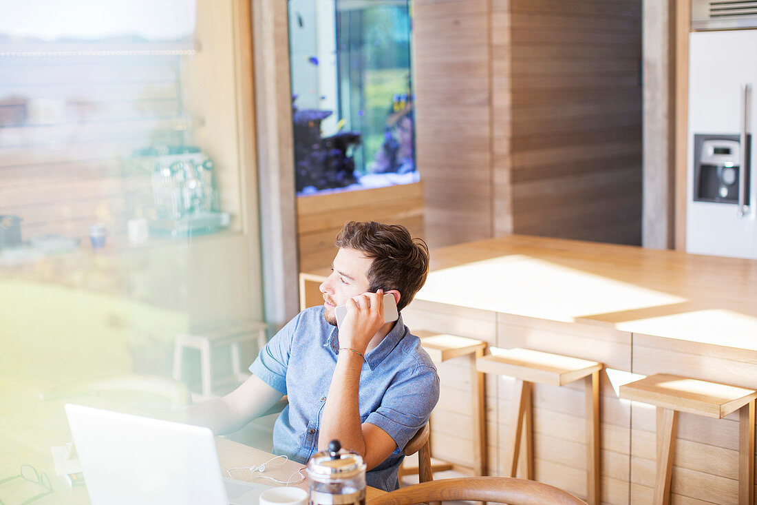 Man talking on cell phone in kitchen