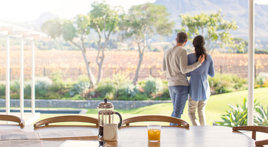 Couple hugging on patio overlooking field