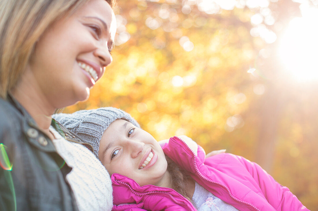 Mother and daughter below autumn leaves