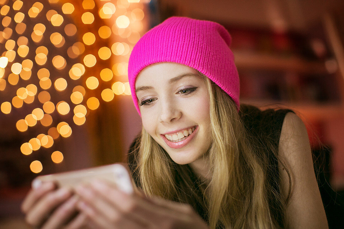 Teenage girl in pink beanie texting