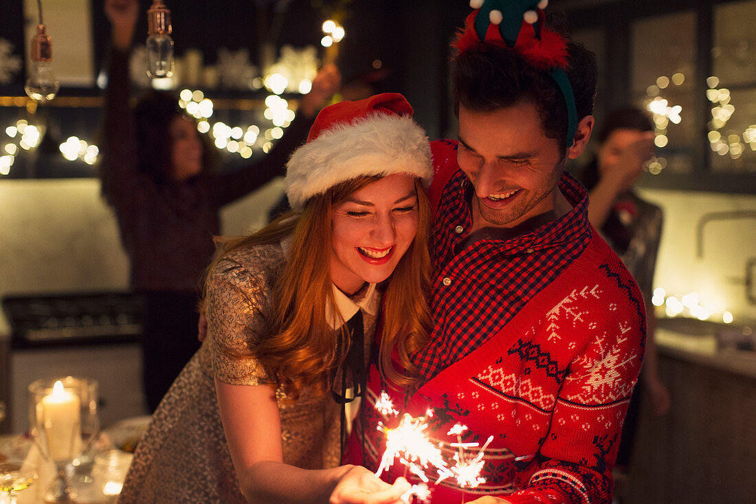 Playful couple with Christmas sparklers