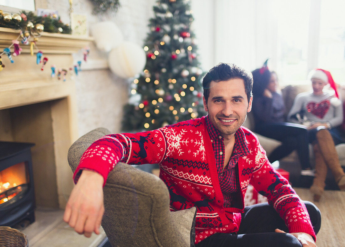 Man in Christmas sweater sitting