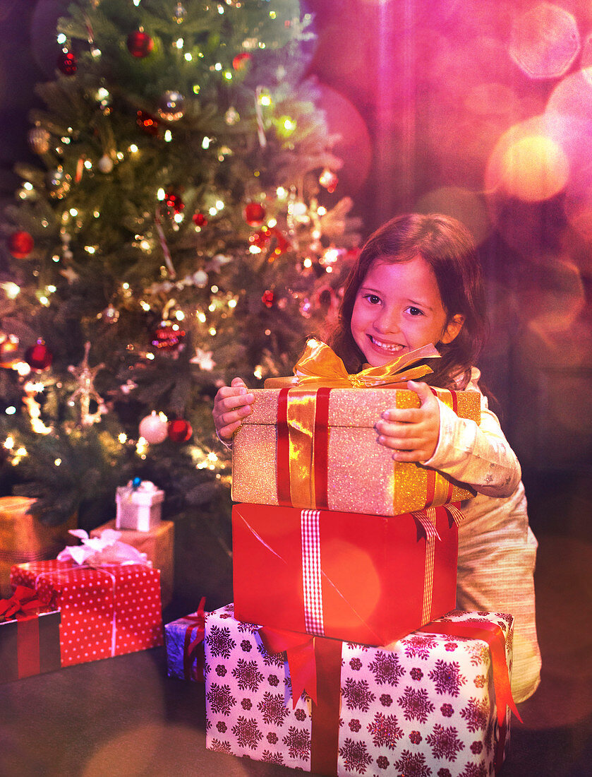 Girl with stack of Christmas gifts