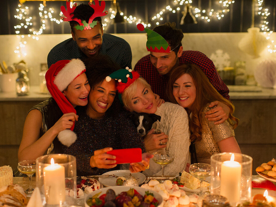 Friends taking selfie at Christmas table