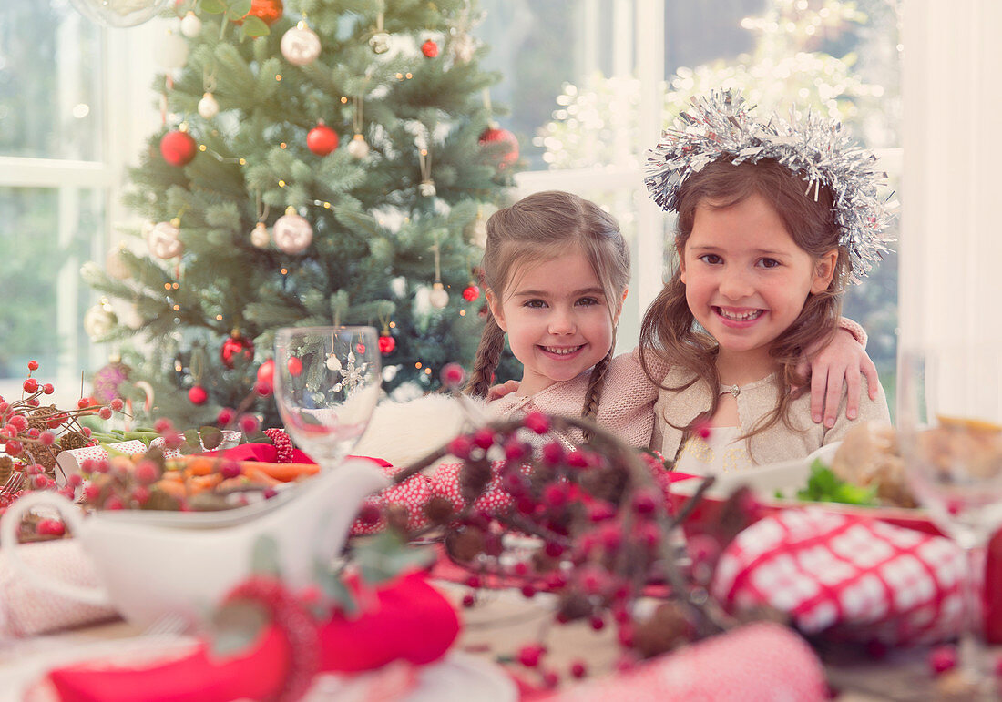 Portrait smiling girls at Christmas table