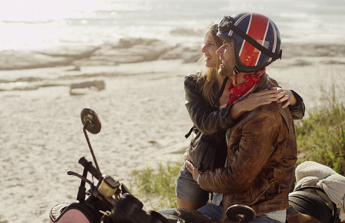 Young couple hugging at motorcycle