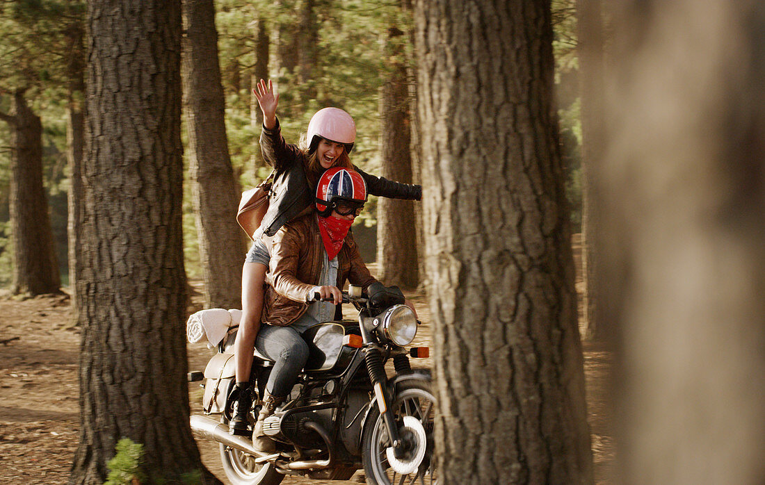 Exuberant young woman riding motorcycle