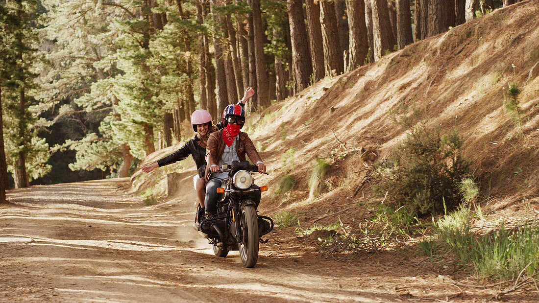 Exuberant young woman riding motorcycle